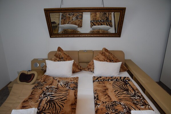 A double bed with a zebra print bedspread, two white pillows, and a mirror above. - Apartment in Essen with Terrace, Parking (Essen)