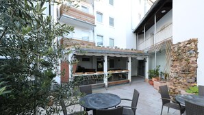 An outdoor patio with wicker furniture, a stone wall, and a covered seating area. - Apartment in Essen with Balcony (Essen)