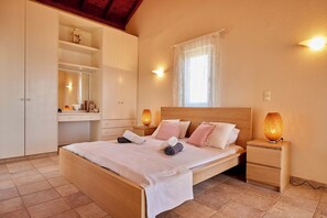 A bedroom with a bed, bedside tables, a nightstand, a wardrobe, and a window with curtains. - Edem Paradise in Plimmiri (Plimmiri)