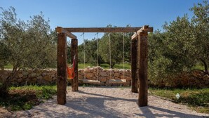 A rustic wooden pergola structure with a hammock hanging from it, set against a backdrop of olive trees and a stone wall. - Eco Villa Solus with two pools (Drage)