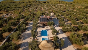 An aerial view of a villa with a swimming pool, surrounded by olive groves and a mountainous backdrop. - Eco Villa Solus with two pools (Drage)