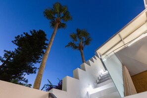 A modern building with a glass staircase and palm trees. - A beach retreat, with 3 bedrooms, 2 full baths, up to 5 guests! (Rethymno)