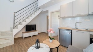 A modern kitchen with white cabinets, a built-in oven, and a stainless steel dishwasher. - Anastasia Residential Complex (Pangaio)