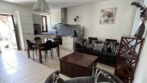 Ein modernes Wohnzimmer mit Sofa, Couchtisch und Essbereich.