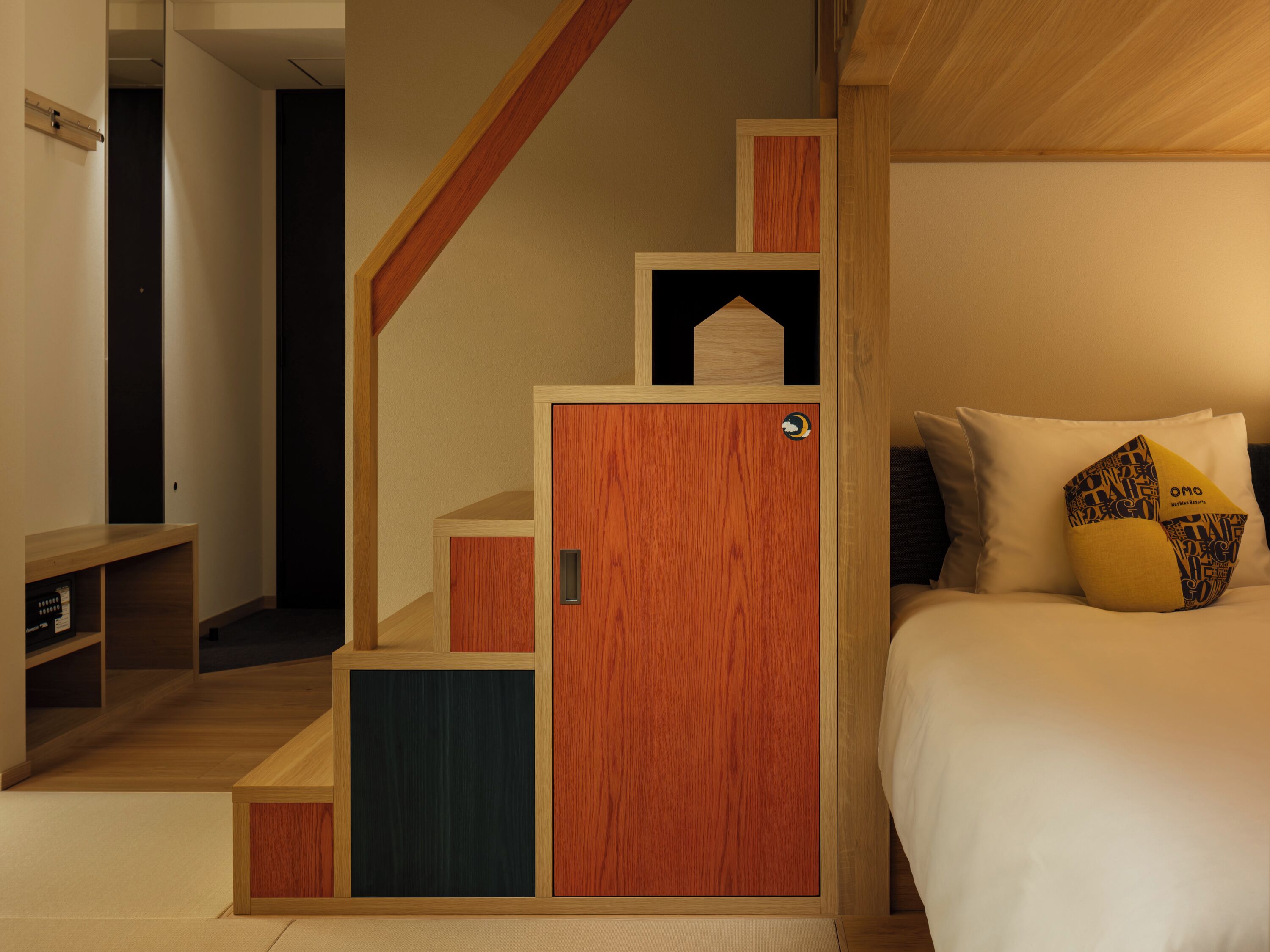 A bedroom with a wooden staircase, a bed with white bedding, and a nightstand.