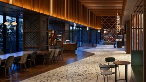 A modern interior with a long corridor, wooden paneling, a patterned floor, and seating areas. - OMO5 Tokyo Gotanda by Hoshino Resorts (Tokyo)