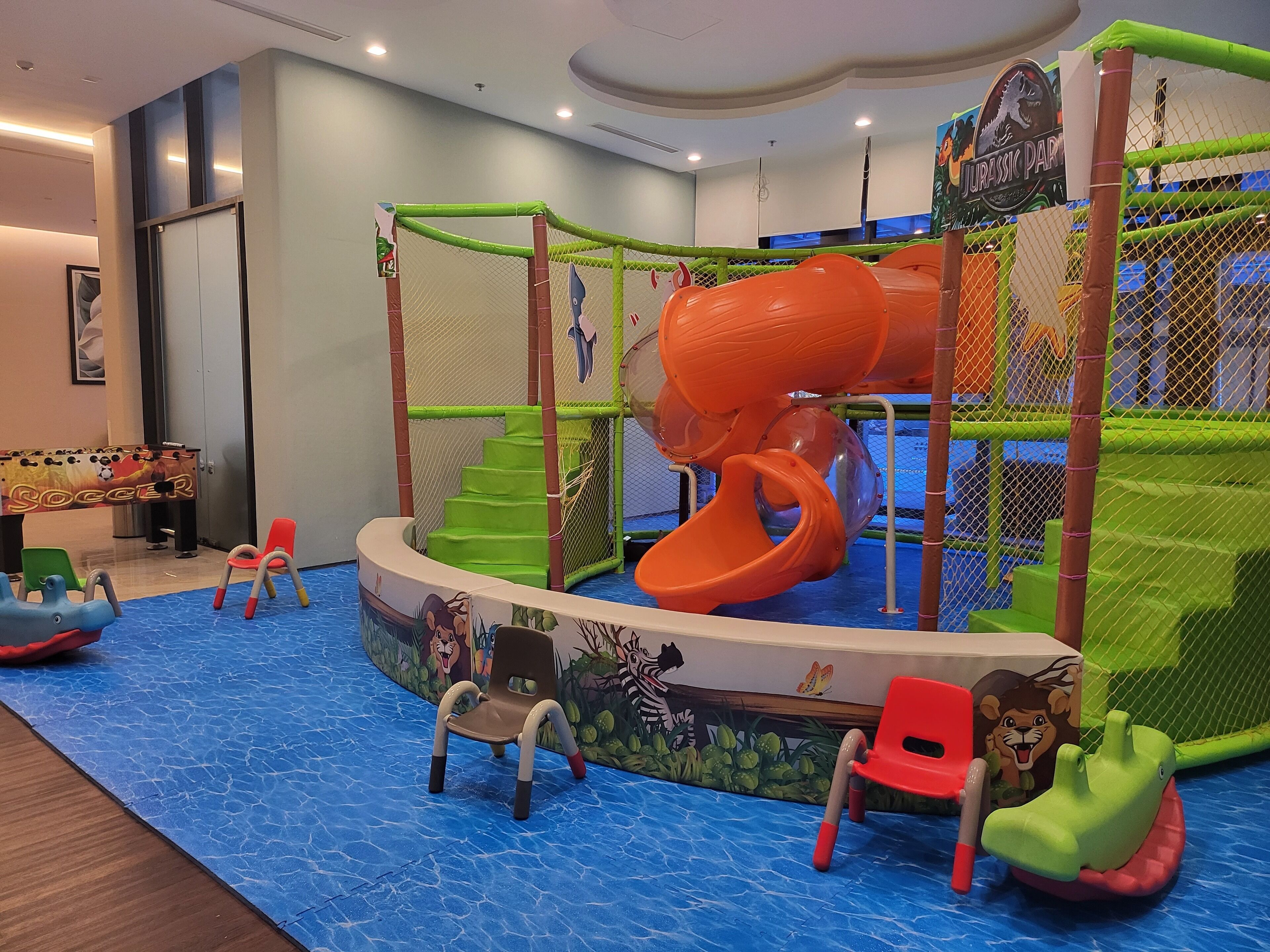 Ein Spielbereich für Kinder mit Rutsche, Kletternetz und thematisch gestalteten Spielgeräten.