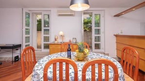 Comedor con una mesa redonda, sillas, una lámpara y un frutero.