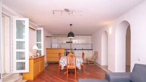 Espacio habitable compacto con comedor, kitchenette y sofá.