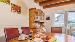 A dining table with plates of food, a cup of coffee, and a wooden cabinet.