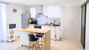 Une cuisine moderne avec des armoires blanches, un plan de travail en bois et une cuisinière noire.