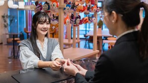 A restaurant interior with a counter, plush toys on display, and a modern interior design.
