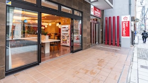 A hotel entrance with a modern design, a visible craft beer sign, and a clear view of the interior seating area.