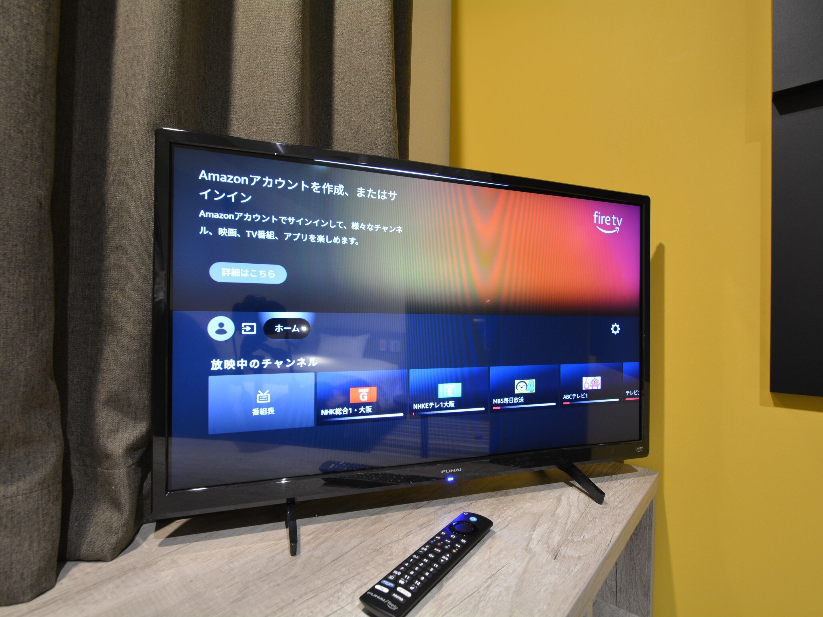 Un televisor sobre un soporte con un control remoto al frente.