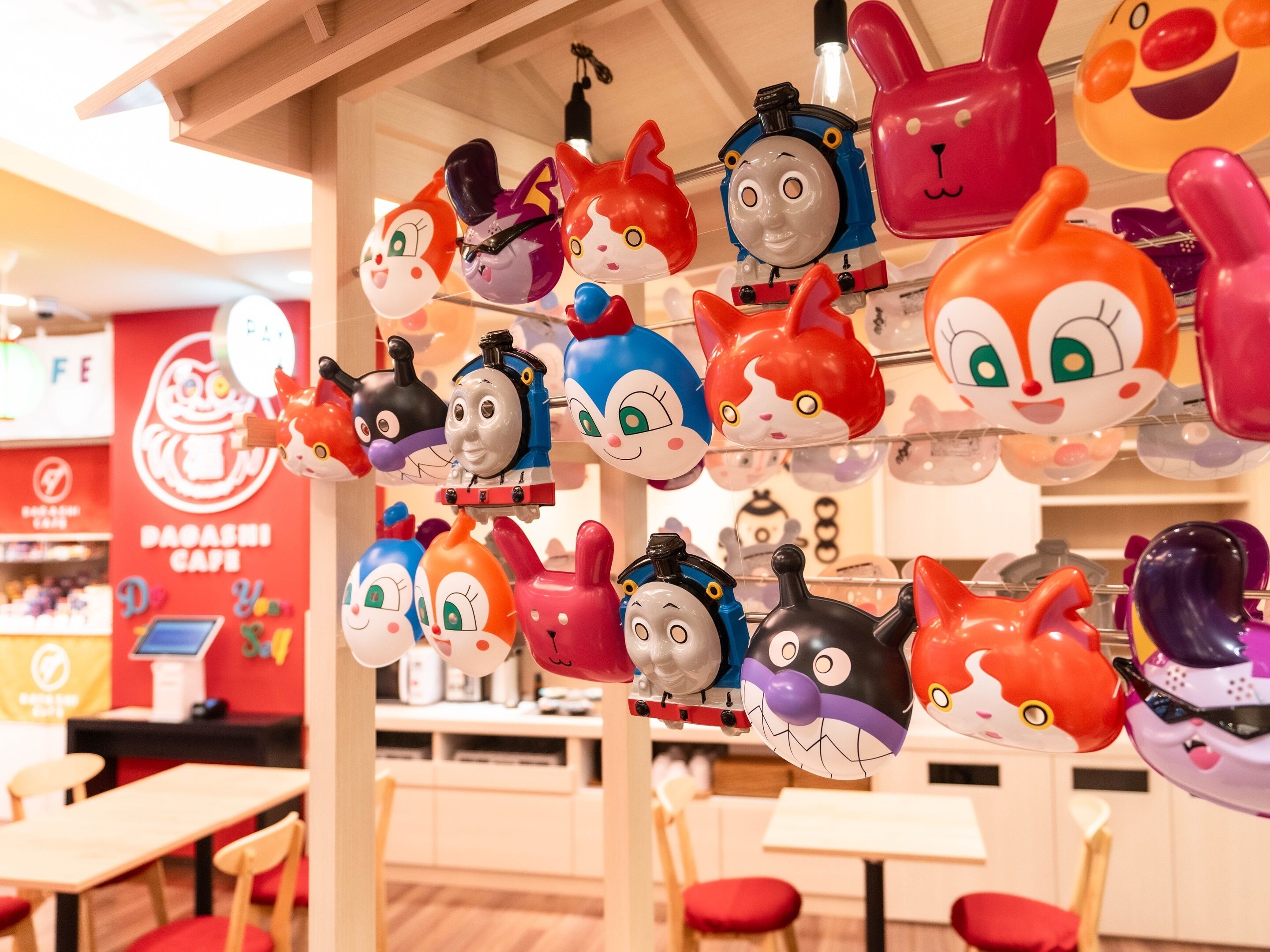 A children's play area with various toy figures and a red sign with Japanese characters.