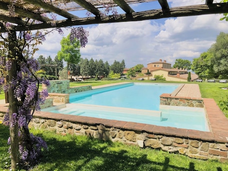 Una piscina al aire libre de temporada, sombrillas