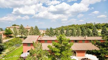 Un quartiere residenziale con diverse case, cielo sereno e vista sul mare.