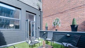 A patio with outdoor seating, a glass door, and a brick wall. - Dukes Street Apartment Hotel (Liverpool)