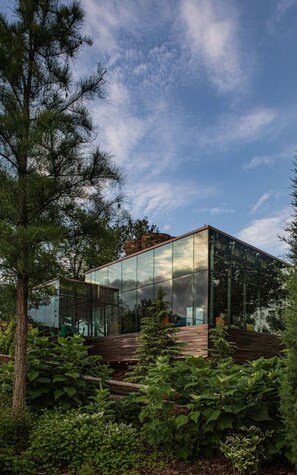 Un bâtiment moderne en verre, entouré d’une végétation luxuriante.