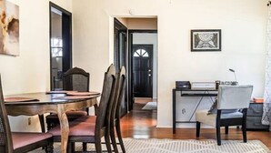 A dining area with a wooden table and chairs, a ceiling fan, and a rug. - Trailside Retreat in the City (Tulsa)