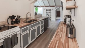 A modern kitchen with a central island, built-in oven, and stainless steel appliances.