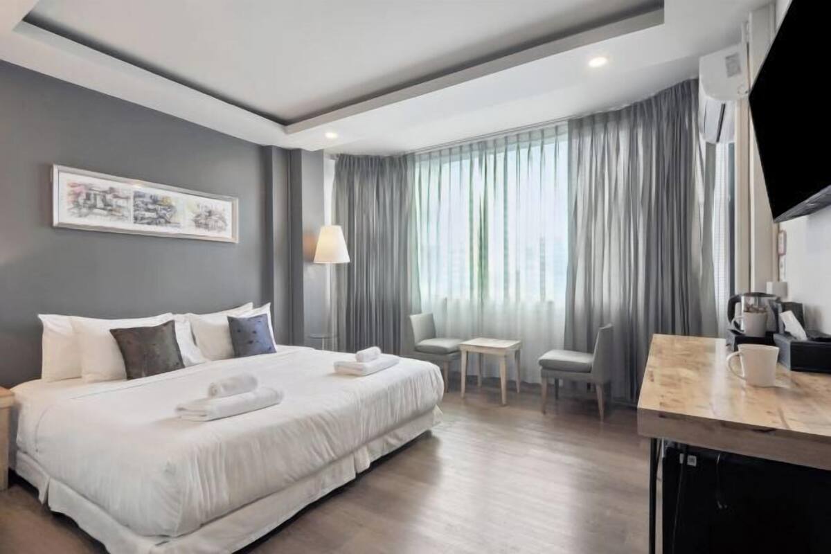 Minibar, escritorio, cortinas opacas y tabla de planchar con plancha