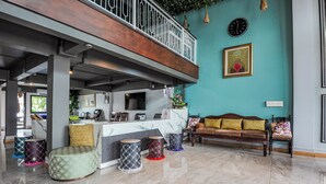 Eine geräumige Lobby mit hoher Decke, einem Empfangsbereich, einem Sofa und einem Couchtisch.