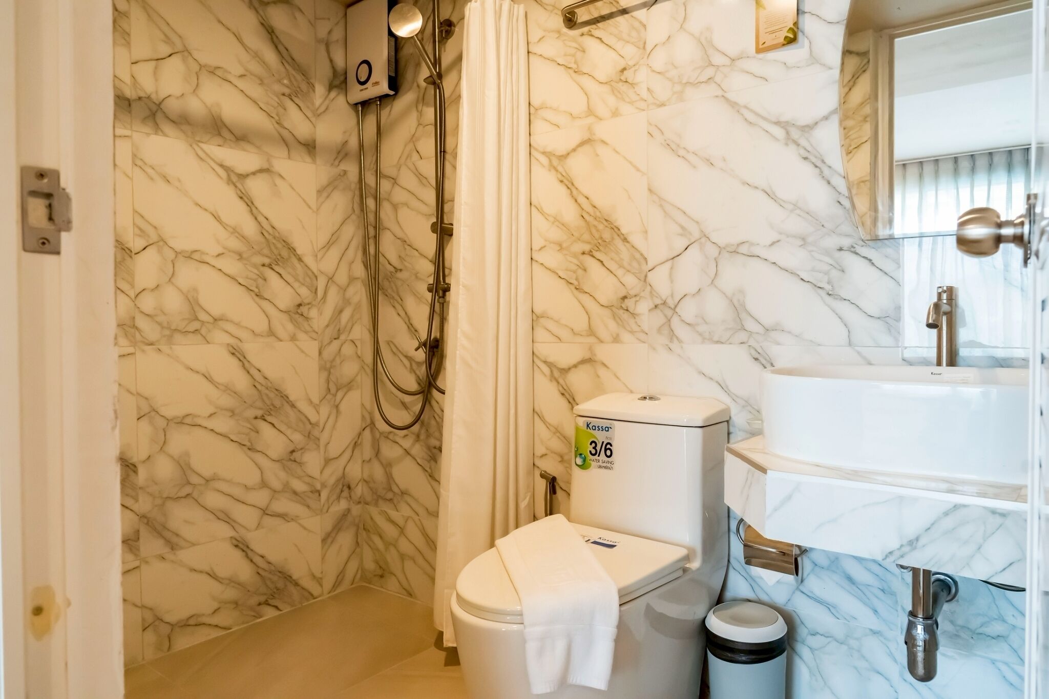 Et badeværelse med toilet, håndvask og brusebad.