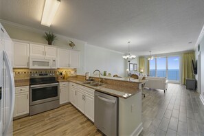 A modern kitchen with stainless steel appliances, a dishwasher, and a granite countertop. - Emerald Isle #2103! 2/2 Gulf Front with Amazing Views of the Gulf of Mexico! (Panama City Beach)