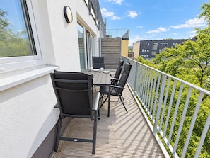 A balcony with a table and chairs, a railing, and a view of the cityscape. - Vacation rental (new construction 2023) in prime location with fireplace and bal (Winterberg)