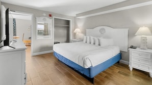 Un dormitorio con cama, mesitas de noche, armario y espejo.