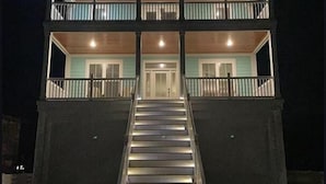 A two-story building with a central staircase leading to the entrance.