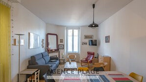 Una sala de estar moderna con sofá, mesa de comedor, sillas y chimenea.