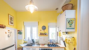 Una cocina equipada con refrigerador, estufa, fregadero y varios electrodomésticos.