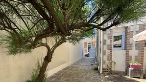 Un estrecho sendero de piedra que lleva a un edificio con una ventana y una puerta.