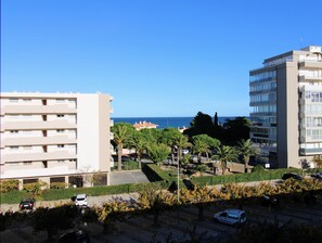 Uma área urbana costeira com edifícios altos, céu claro e vista para o mar.