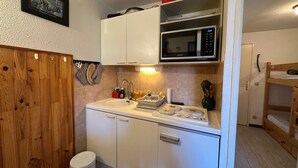 A compact kitchen with a microwave, sink, and cabinets. - Cozy 2-room flat without lift, for 4/5 people, Morillon 1100 (Morillon 1100)