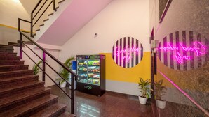 A modern interior with a staircase, vending machine, and neon signs on the walls. - Olive Hotel JP Nagar by Embassy Group (Bengaluru)