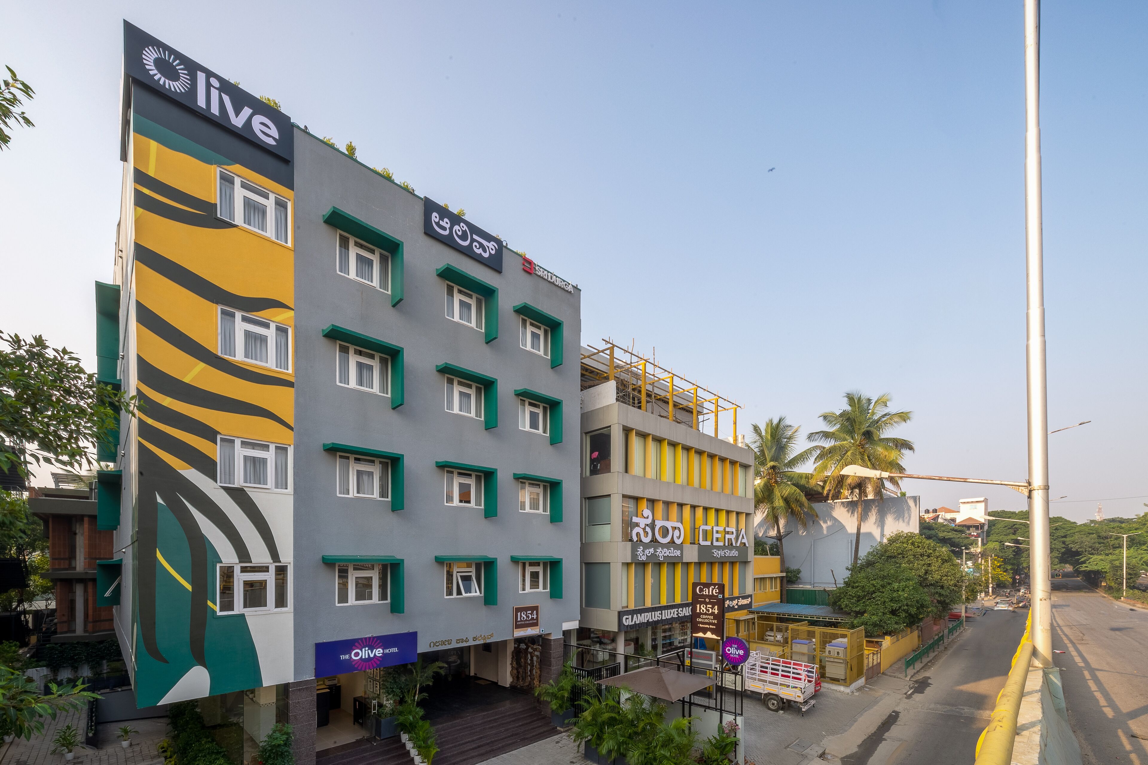 A multi-story hotel with a modern design, featuring a prominent 'live' sign and a 'Cera' sign on the facade.