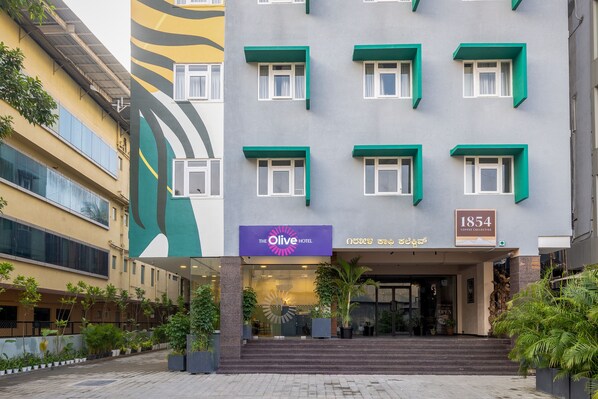 A hotel entrance with a sign reading "The Olive Hotel" and "1854 Coffee Collective". - Olive Hotel JP Nagar by Embassy Group (Bengaluru)