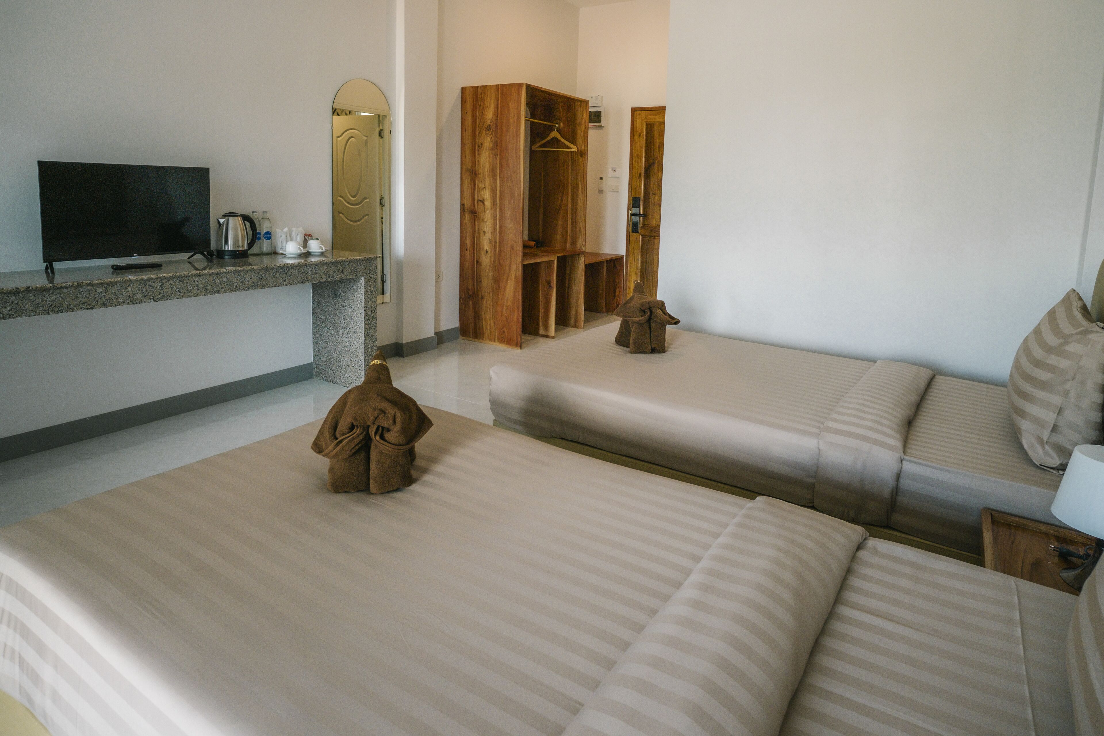 Ein Hotelzimmer mit Fernseher, einem Holzschrank, einer Couch und einem kleinen Tisch.