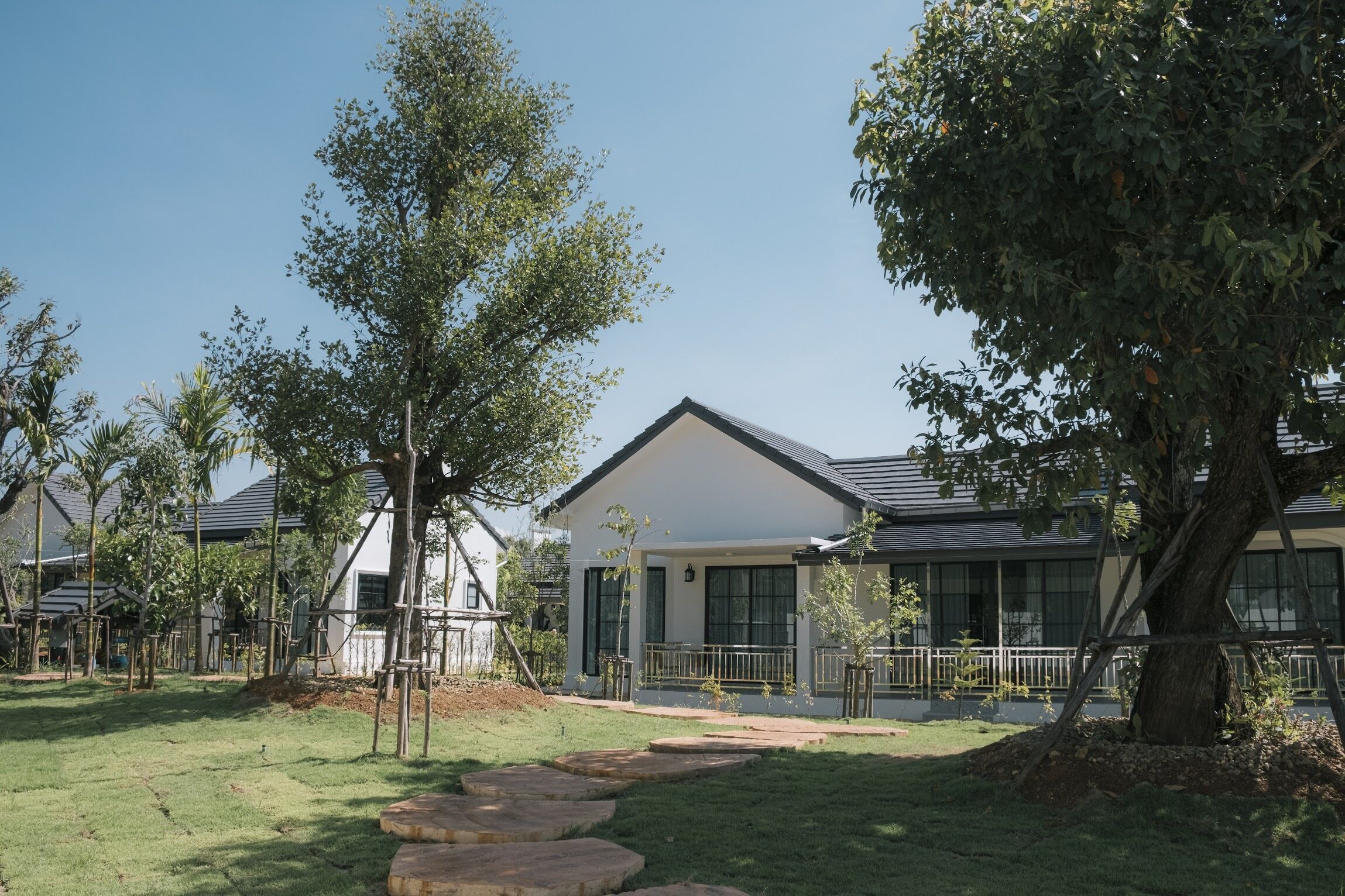 A modern house with a white exterior, a sloped roof, and a front porch.