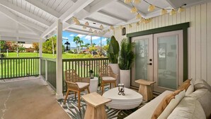 A covered outdoor area with a sofa, chairs, and a table.
