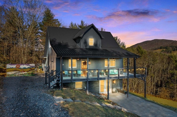 A two-story house with a balcony, a front porch, and a driveway.