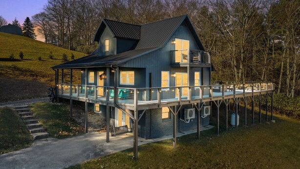 A two-story house with a balcony and a covered porch. - Spacious 3BR chalet in Fleetwood, NC, perfect for family gatherings, sleeps 10. (Fleetwood)