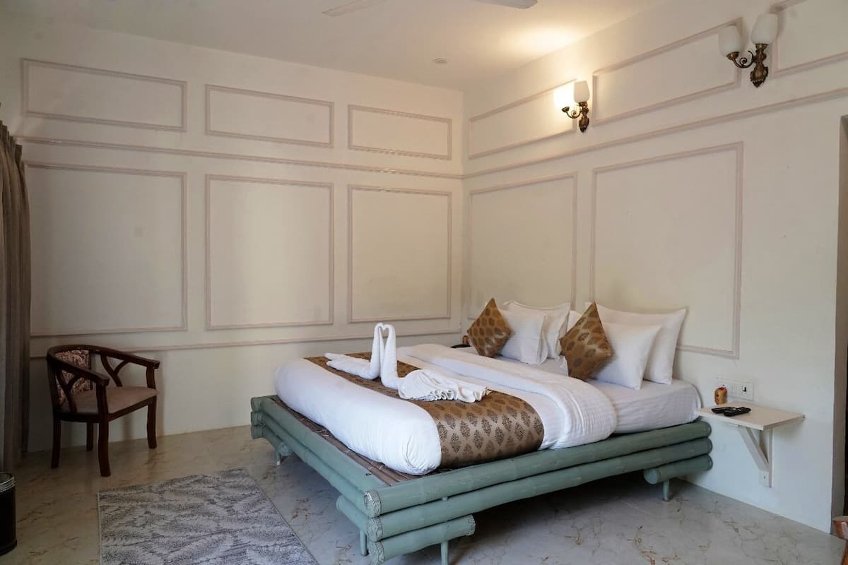 A bedroom with a bed, a chair, and a small bedside table.