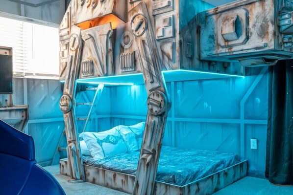 A room with a bunk bed, a blue-lit canopy, and a rustic wall design.
