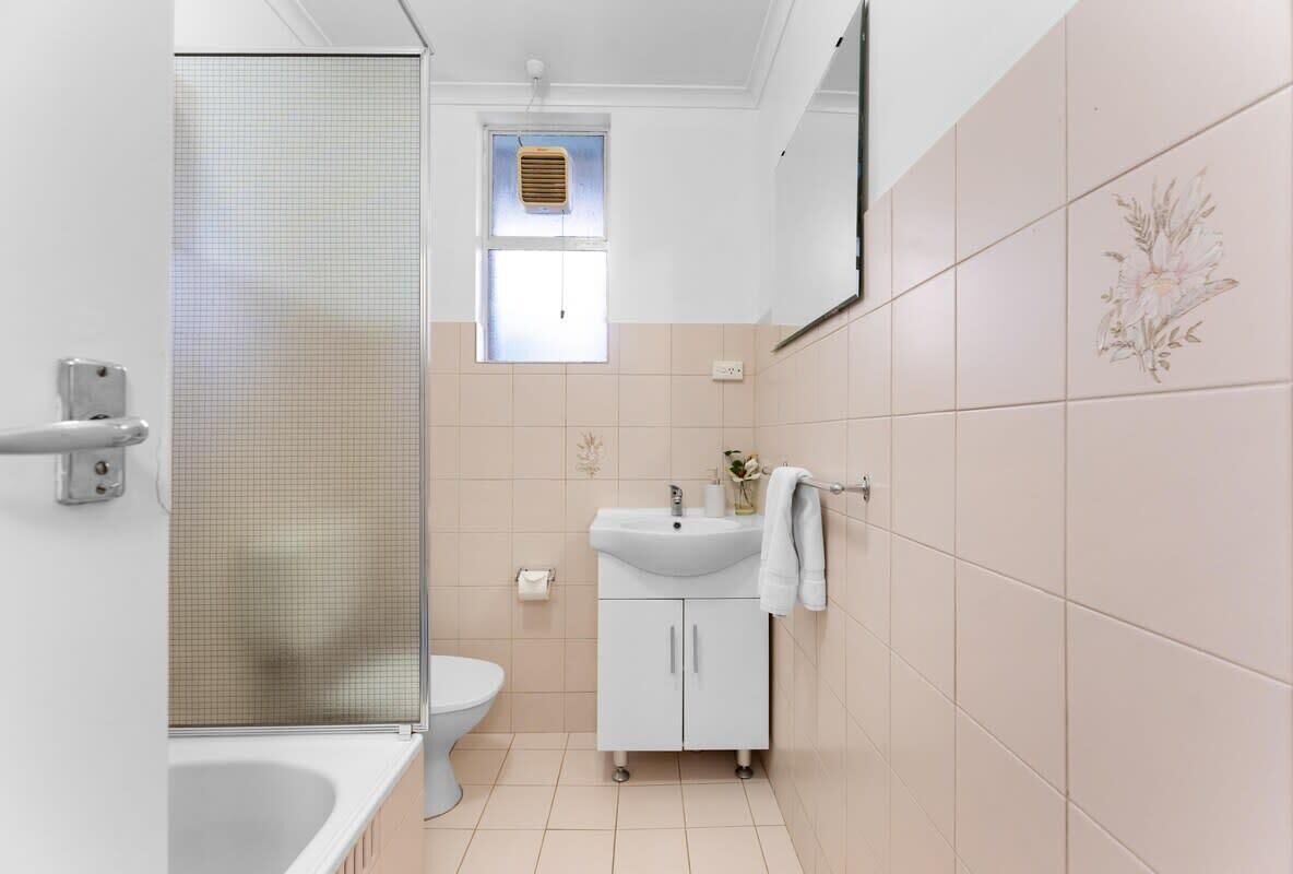 A bathroom with a bathtub, toilet, and sink.