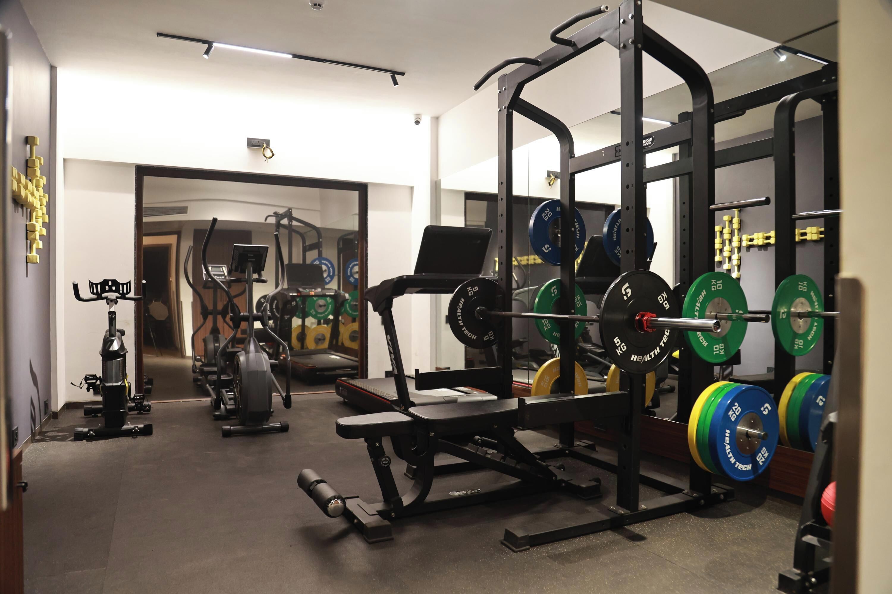 Una palestra con attrezzature per sollevamento pesi, tapis roulant e cyclette.