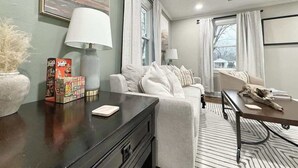 A modern living room with a sofa, a coffee table, and a lamp. - Stylish 2BR in Decatur | Big Deck • Pets OK • Quiet Area (Decatur)